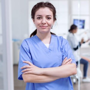 Nurse in dental reception with arms crossed